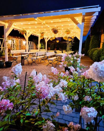 a pavilion with benches and flowers in a courtyard at Pensjonat Retro in Łomża