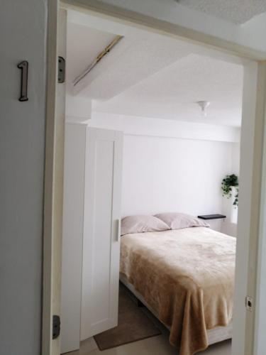 a bedroom with a bed in a white room at (1) Cuarto confortable en la zona de Angelópolis. in Tlazcalancingo
