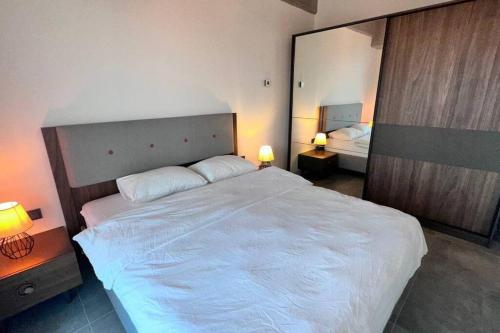 - une chambre avec un grand lit blanc et un miroir dans l'établissement Central Residence with Balcony, à Istanbul