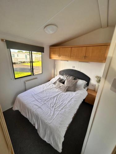 a bedroom with a large bed in a trailer at Wigbay Loch View 28 in Kirkcolm