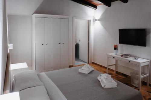 a bedroom with a couch and a desk and a tv at Agriturismo Fattoria San Sebastiano in Strongoli