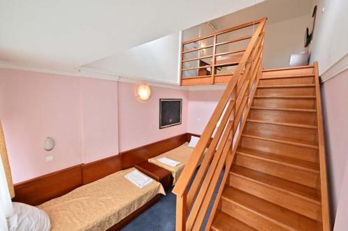 Habitación con 2 camas y escalera. en Hotel Norcev, en Grgeteg