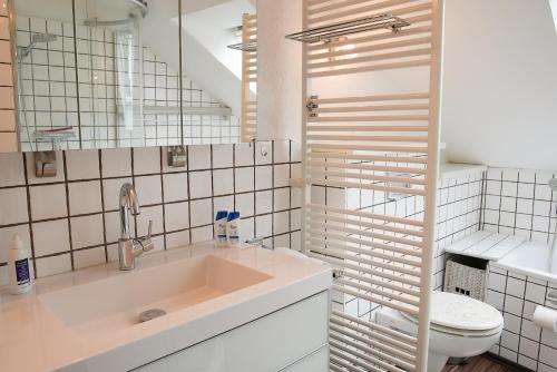 Baño blanco con lavabo y aseo en Remark Studios - Wohnung für 6 in Großburgwedel, en Burgwedel