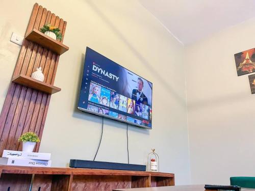 a flat screen tv hanging on a wall at Cozy & tranquil 1 Bedroom dainty haven in Kampala in Buwate