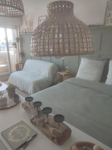 um quarto com 2 camas e um lustre em Appartement liberty em Courseulles-sur-Mer