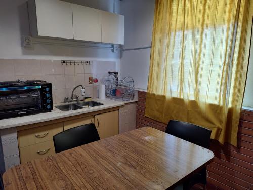 cocina con mesa de madera y fregadero en Rinconada 736 Sustentable, en San Salvador de Jujuy