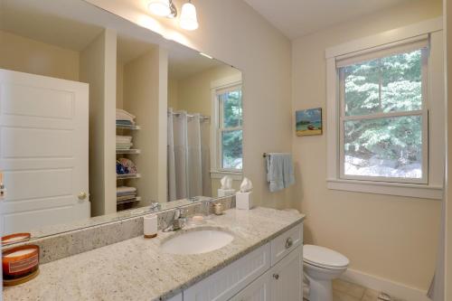 a bathroom with a sink and a toilet and a mirror at Inviting Summer Village Cottage Golf Cart and More! in Westford