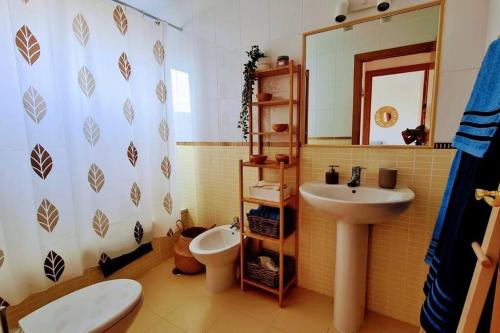 a bathroom with a sink and a toilet and a mirror at Vivienda en Lajares " Casa Sua " in La Oliva