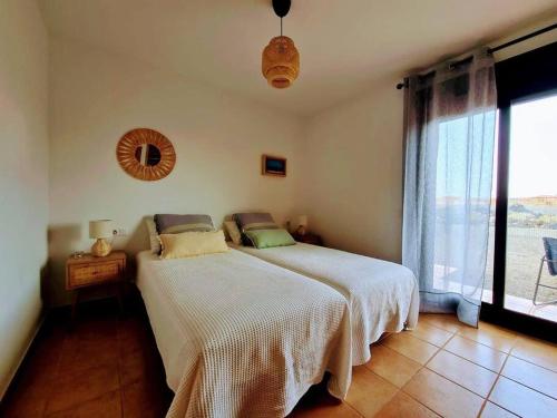 a bedroom with a bed and a large window at Vivienda en Lajares " Casa Sua " in La Oliva