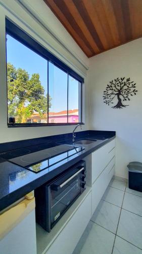 a kitchen with a sink and a window at Pousada Pura Vida Maresias in Maresias