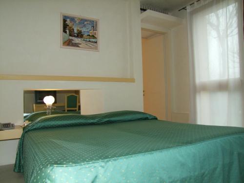 a bedroom with a green bed and a window at Hotel Villa Ca' Sette in Bassano del Grappa