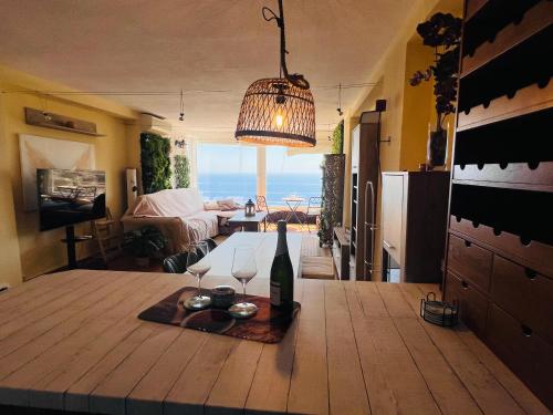 a room with a table with a bottle and wine glasses at Horizonte Azul in Almería