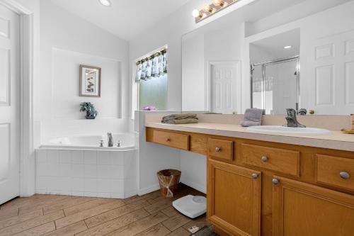 La salle de bains est pourvue d'une baignoire, d'un lavabo et d'une baignoire. dans l'établissement 201 Hideaway beach 4 beds - pool&spa, à Kissimmee
