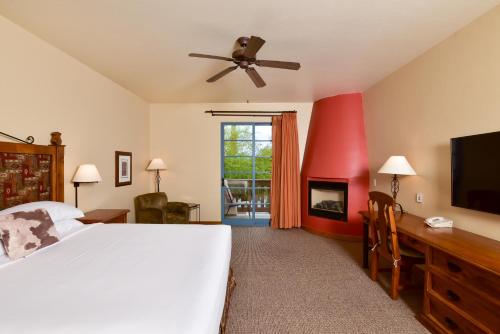 a bedroom with a white bed and a tv at Lodge On The Desert in Tucson