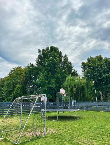 a net with a basketball hoop on a field at Pilkas Namelis - Namelių nuoma Šventojoje in Šventoji