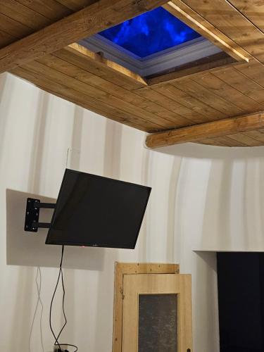 Elle comprend une télévision à écran plat suspendue au plafond. dans l'établissement TRULLO AURORA BOREALE, à Alberobello