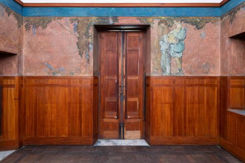 an empty room with wooden doors and a painting on the wall at Casa Cuseni, Patrimonio Culturale Immateriale UNESCO in Taormina