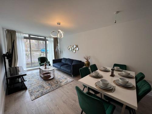 uma sala de estar com uma mesa e um sofá azul em C5, Spacious 3 bedroom flat in Wembley em Londres