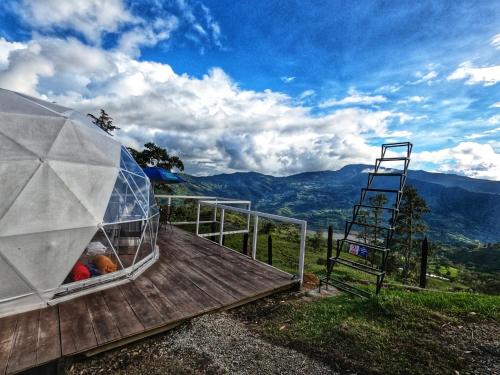 una casa de cristal en una terraza de madera con una escalera en Glamping Campestre Uriyahu, en Macanal