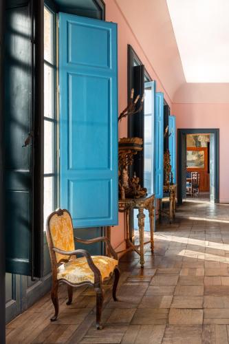 a room with a blue door and a chair at Casa Cuseni, Patrimonio Culturale Immateriale UNESCO in Taormina