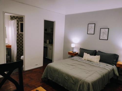 ein Schlafzimmer mit einem Bett und einer Tür zu einer Küche in der Unterkunft Monoambiente 76 in Mendoza