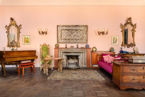 a living room with a fireplace and a piano at Casa Cuseni, Patrimonio Culturale Immateriale UNESCO in Taormina
