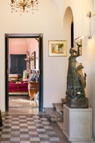 a living room with a statue in theoyer at Casa Cuseni, Patrimonio Culturale Immateriale UNESCO in Taormina