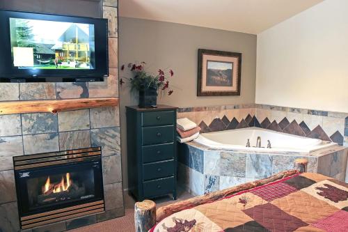 une salle de bain avec baignoire, télévision et cheminée dans l'établissement Fawn Valley Inn- 105 condo, à Estes Park