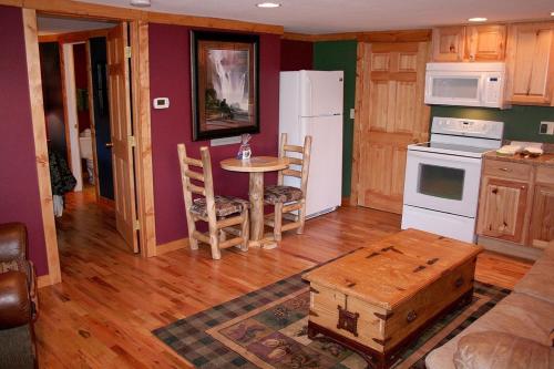 a kitchen with a table and a white refrigerator at Timber Creek Chalets- 10A chalet in Estes Park