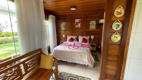 a bedroom with a bed in a wooden room at Pedacinho de Chão Chalés in Visconde De Maua