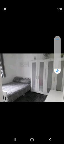 Zimmer mit 2 Betten und einem iPhone in der Unterkunft Bexley Rooms in Streatham