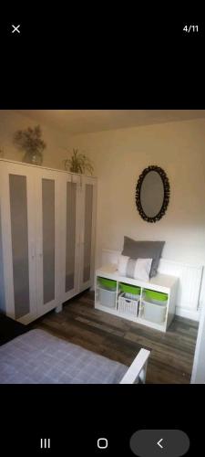 Schlafzimmer mit einem Bett und einem Wandspiegel in der Unterkunft Bexley Rooms in Streatham