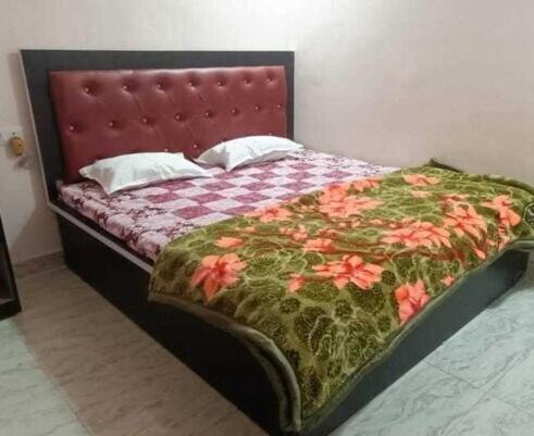 1 cama con edredón y almohadas de flores en OYO 81285 Hotel Chanda, en Madhubani