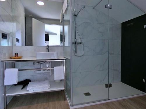 a bathroom with a shower with a glass door at Apartamentos Dabarca Combarro in Combarro
