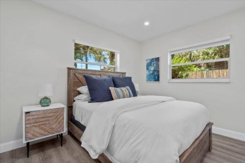 a white bedroom with a bed and two windows at Immaculate, Private Home Near Ft. Lauderdale Beach in Fort Lauderdale
