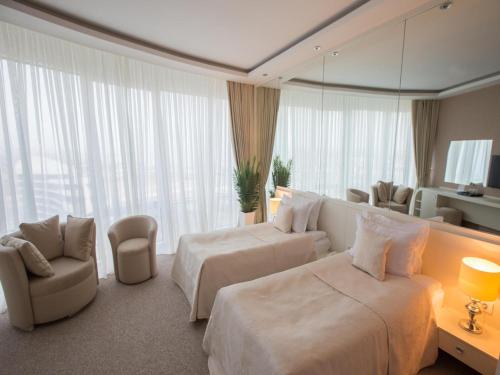 a hotel room with two beds and a mirror at Qafqaz Sahil Hotel Baku in Baku