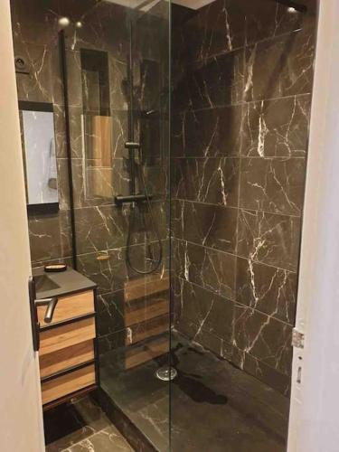 een badkamer met een douche en een glazen deur bij Sarah B in Marseille