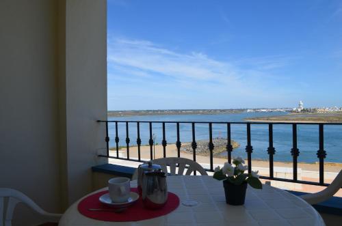 una mesa con vistas al océano desde el balcón en Apartamentos Punta Canela, en Isla Canela