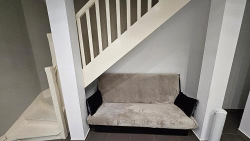 a chair sitting under a stairs with a stair case at Le patio St Étienne - Cité Épiscopale - Parking inclus in Albi