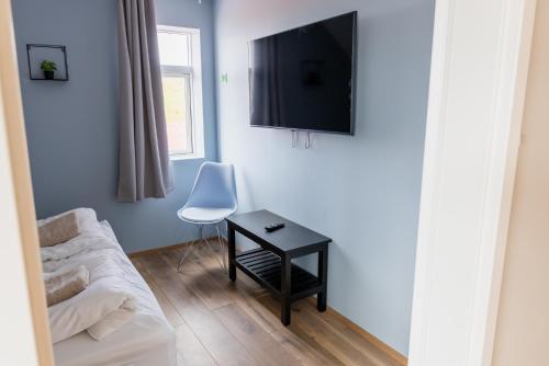 a living room with a couch and a table and a tv at Big house with a view in Akureyri