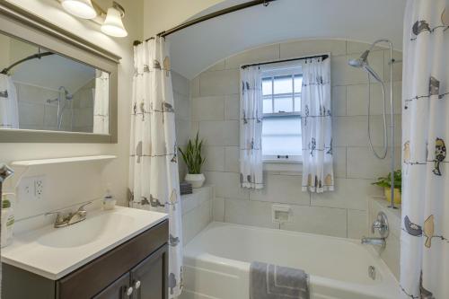 a bathroom with a tub and a sink and a mirror at Glendive Getaway with Yellowstone River Access! in Glendive