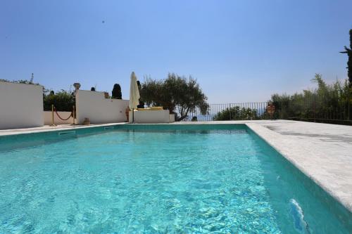 a swimming pool in a villa with blue water at Casa Cuseni, Patrimonio Culturale Immateriale UNESCO in Taormina