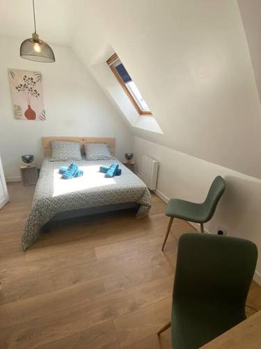 a bedroom with a bed and a chair in it at joli duplex centre ville 5 min à pied de la gare sncf in La Loupe