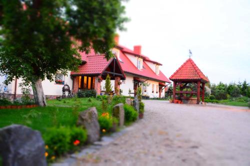 a house with a red roof and a gazebo at Siedlisko Sabinowo in Węgorzewo