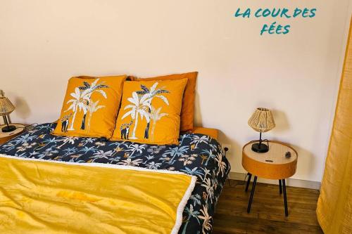 a bedroom with a bed with yellow sheets and palm trees at Appartement La Roche-Bernard - Plein centre - 50m² in La Roche-Bernard