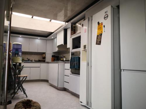a kitchen with white cabinets and a refrigerator at Casa Pabón in Bogotá