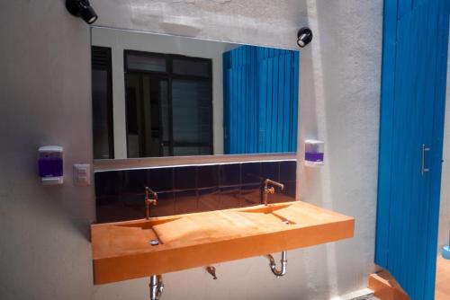un bagno con lavandino e specchio di HOSTAL CHOCOLATE CALENDA a Città di Oaxaca