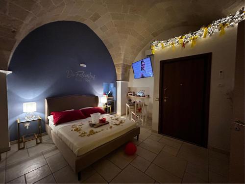 a bedroom with a bed and a tv on a wall at Relaxing Rooms in Pulsano