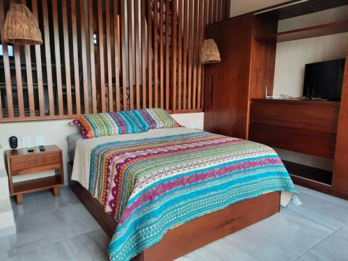 um quarto com uma cama e uma televisão em Chic PH Private Pool/Rooftop near to beachfront em Tulum