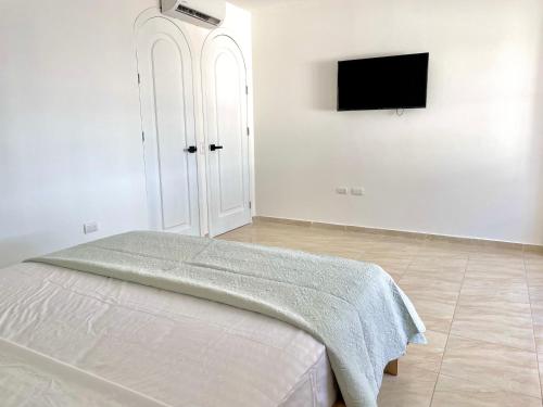 a bedroom with a bed and a flat screen tv at Beautiful 2 bedroom, pool, beach in Manta